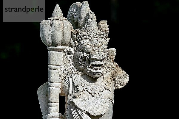 Leicht beschädigte Gartenstatue eines balinesischen Tempelwächters  der ein Arm fehlt