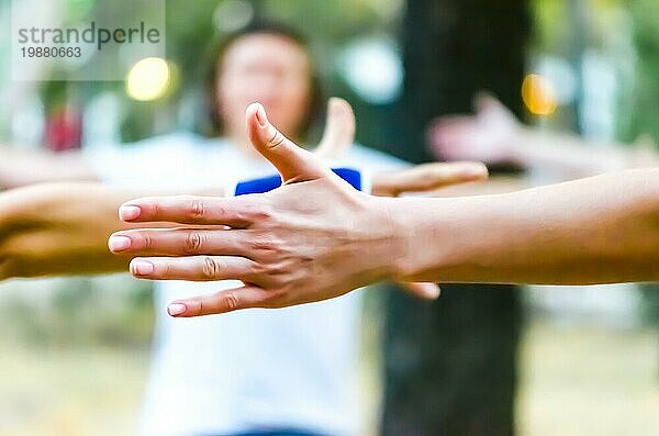 Die Hände der Menschen sind erhoben Yoga im Park im Freien
