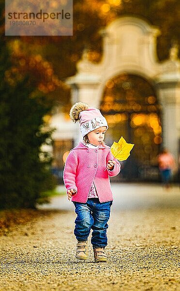 Baby Mädchen im Herbst Park zu Fuß mit gelben Blatt. Eggenberg Park in Graz Österreich