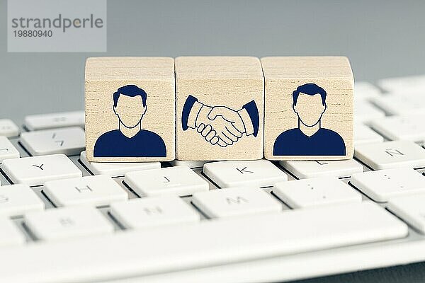 Online Deal Konzept. Zwei menschliche Symbol und Handshake Symbol auf Holzblöcken auf Computertastatur