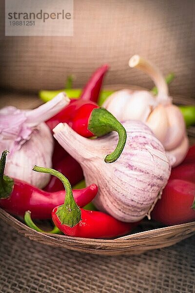 Lebensmittelstillleben mit Knoblauch  grünen und roten Chilischoten mit Kopierraum