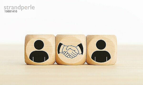 Vereinbarung  Partnerschaft oder Geschäftskonzept. Menschen und Handshake Icons auf Holzblöcken. Kopieren Raum
