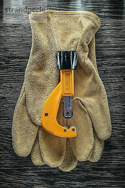Sanitärrohrschneider Lederschutzhandschuhe auf Holzbrett