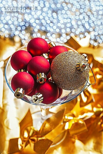 Goldene und rote Weihnachtskugeln im Martini Weinglas