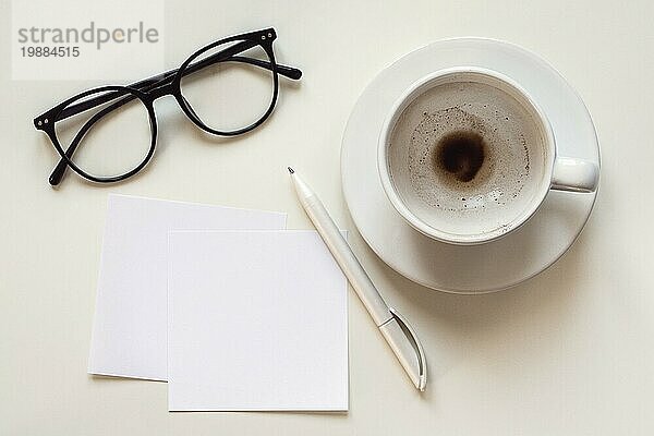 Papier Notizen Mockup  leeren Raum  leere Kaffeetasse  Brille und Stift auf weißem Schreibtisch  Overhead Flachlegung