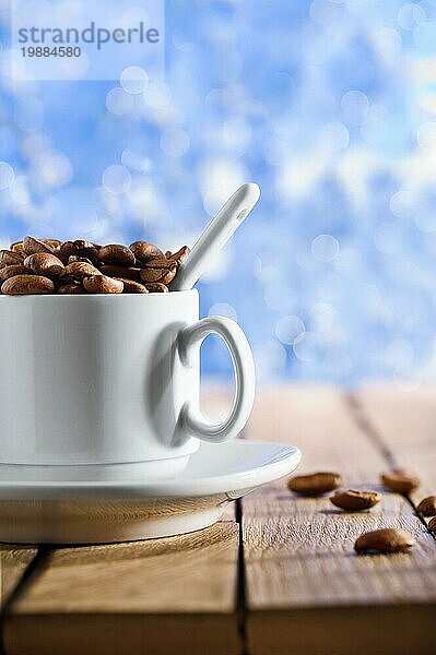 Tasse mit Kaffeebohnen auf dem Holztisch