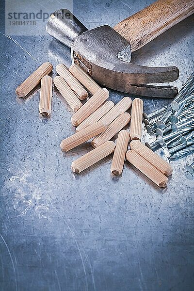 Klauenhammer Haufen von Bau Nägel und Holzdübel auf zerkratzt metallischen Hintergrund Wartung Konzept