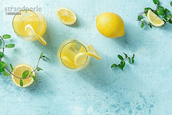 Limonade auf einem blaün Hintergrund mit Platz für Text. Hausgemachtes frisches Getränk mit Zitrone und Minze  mit Eis  Overhead Flachbildaufnahme mit Platz für Text. Gesunde natürliche Sommerdiät
