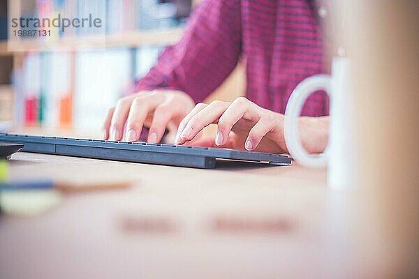 Tippende Hände auf der Tastatur  Heimbüro mit Textfeld