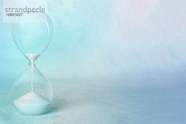Zeit Konzept. Eine Sanduhr mit der Zeit  die zu Ende geht  mit Kopierraum  in teal blau  getöntes Bild
