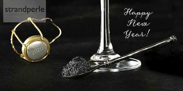 Frohes neues Jahr Panorama mit schwarzem Kaviar  einem Glas Champagner und einem Champagnerkorken mit der Zahl 2020  selektiver Fokus