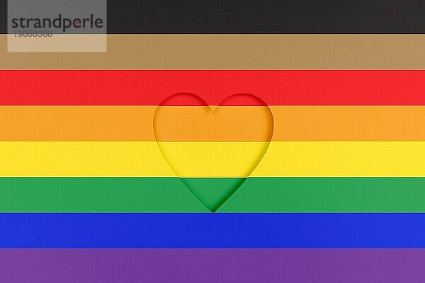 Neu gestalteter Hintergrund für die LGBTQ Stolzflagge. Regenbogen bedruckter Karton mit ausgestanzter Herzform. Ansicht von oben