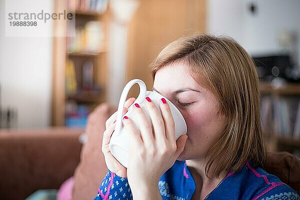 Schöne junge Frau genießt eine Tasse Tee