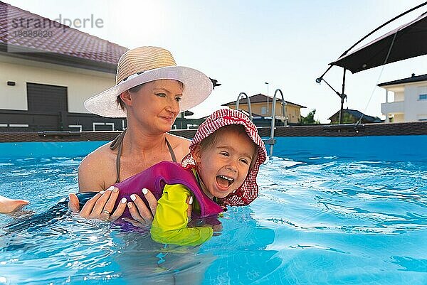 Baby Mädchen mit Mutter im Schwimmbad lernen zu schwimmen. Familie Lebensstil Konzept