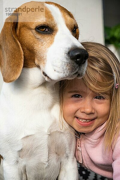 2 Jahre altes Kind umarmt besten Freund Hund. Glückliche Kindheit mit Haustier Beagle. Hund Hintergrund