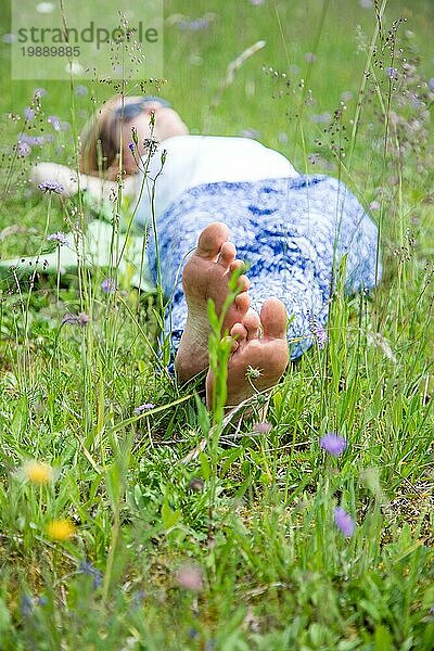 Junges Mädchen im Park liegt im Gras und genießt den Tag