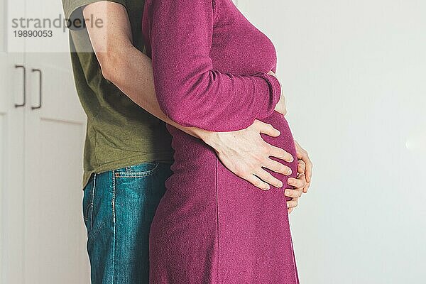 Nahaufnahme einer schwangeren Mutter und eines Vaters  die den Bauch umarmen  Kaukasier