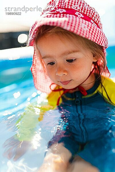 Kind im aufblasbaren Schwimmbad im Hinterhof. Richtiger Sonnenschutz für Babys Konzept