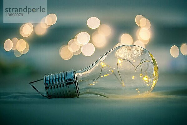 Die LEDglühbirne liegt im Bett. Symbol für Ideen und Innovation. Spotlights im unscharfen Hintergrund