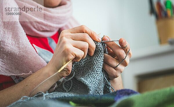 Nahaufnahme von weiblichen Fingern beim Stricken zu Hause