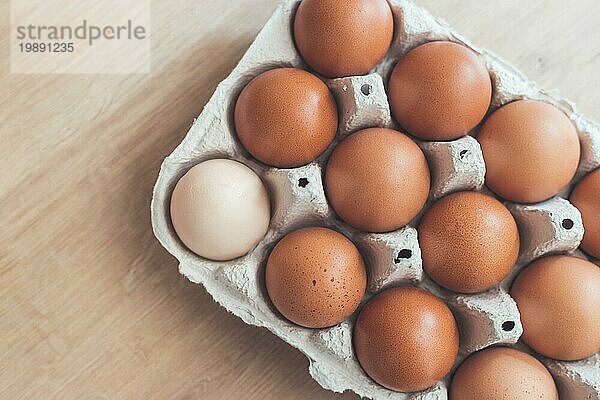 Braune Eier und ein weißes Ei in einem Korb