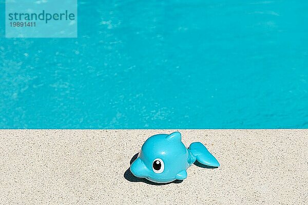Cute Toy Fish auf Schwimmbad Grenze. Summertime Vergnügen Konzept Hintergrund. Kopieren Raum