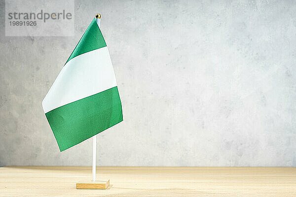 Nigeria Tischflagge auf weißer  strukturierter Wand. Kopierraum für Text  Entwürfe oder Zeichnungen