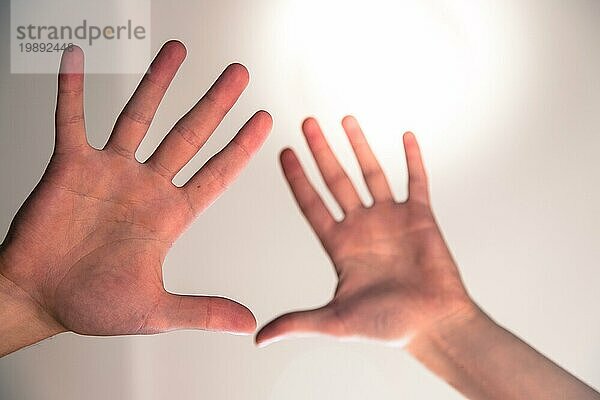 Junge männliche Hände machen eine heilende oder schützende Geste