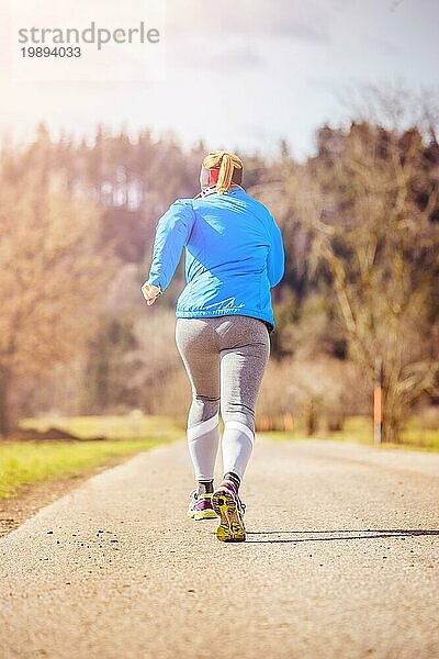 Junge Frau joggt  Landschaft