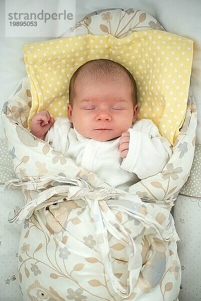 Cute neugeborenes Baby schlafen in swaddle wickeln mit Lächeln auf ihrem Gesicht. Neugeborenes Thema