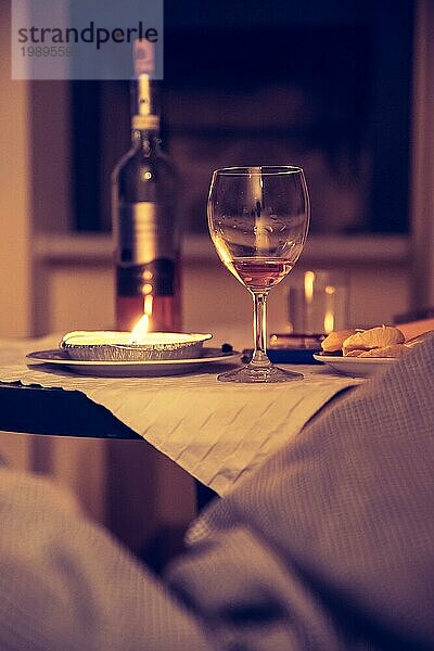 Glas und Flasche Wein an einem Tisch  abgedunkelter Raum