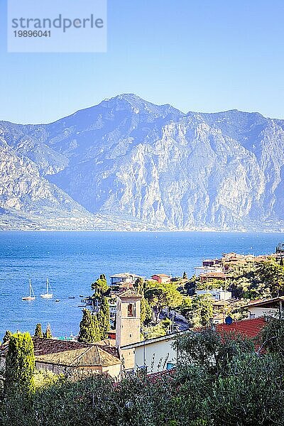 Idyllische Küstenlinie in Italien: Blaues Wasser und ein niedliches Dorf am Gardasee  Malcesine  Sonnenuntergang
