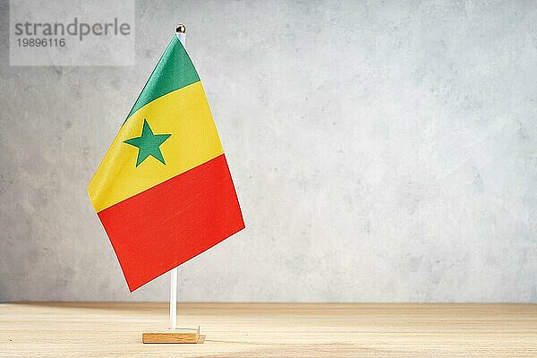 Senegalische Tischflagge auf weißer  strukturierter Wand. Kopierraum für Text  Entwürfe oder Zeichnungen