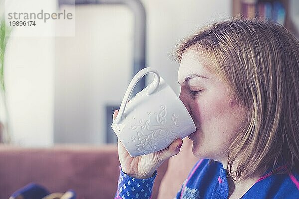 Schöne junge Frau genießt eine Tasse Tee