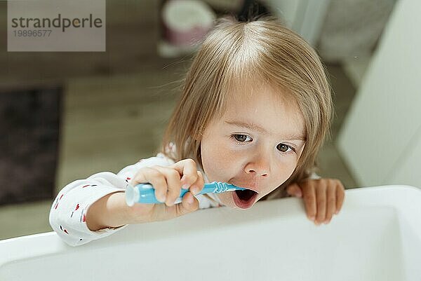 Baby Mädchen in hellen Bad Bürsten ihre Zähne über dem Waschbecken. 23 Jahre altes Kind persönliche Hygiene