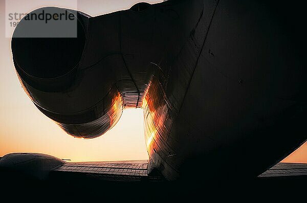 Silhouette Fragment Turbine und Flügel eines großen Verkehrsflugzeugs auf Sonnenuntergang Hintergrund