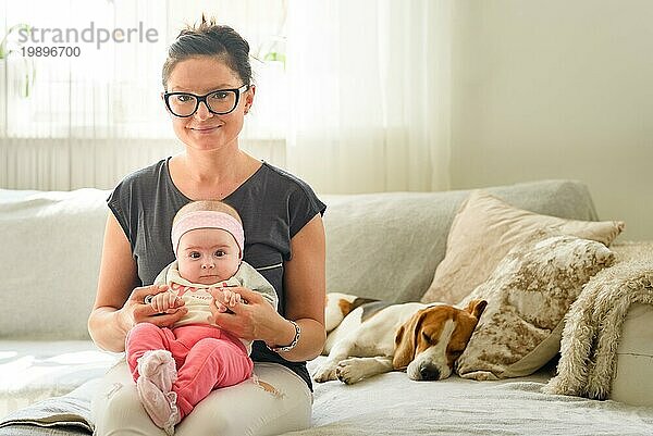 Mutter hält schönes Baby Mädchen in hellen sonnigen Raum. Mutterschaft Hintergrund