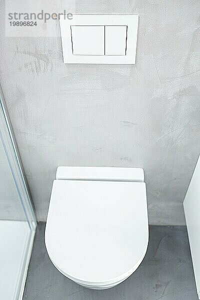 Wandmontierte oder hängende Toilette oder WC im heimischen Badezimmer mit Druckknopfspülung