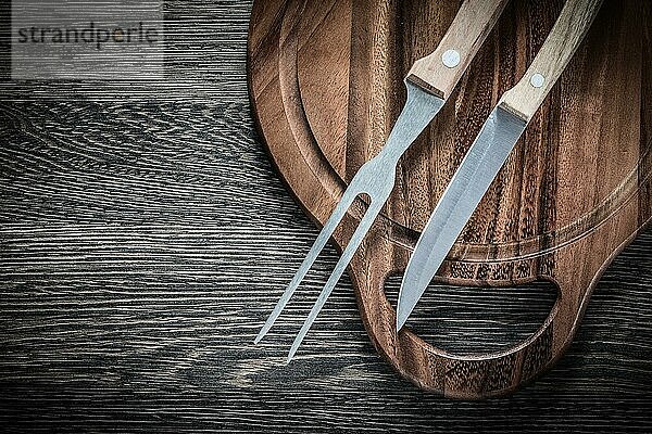Fleischgabel Messer Schneidebrett auf Holz Hintergrund