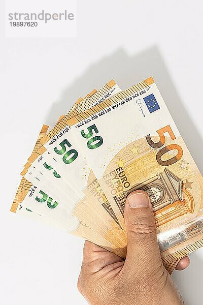 Eine Hand hält eine Gruppe von 50 Euro Banknoten auf weißem Hintergrund. Leerzeichen kopieren