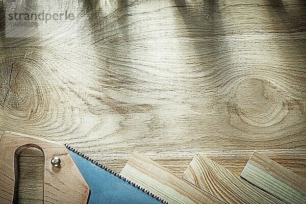 Bügelsäge Holz auf Holzplatte Draufsicht Baukonzept