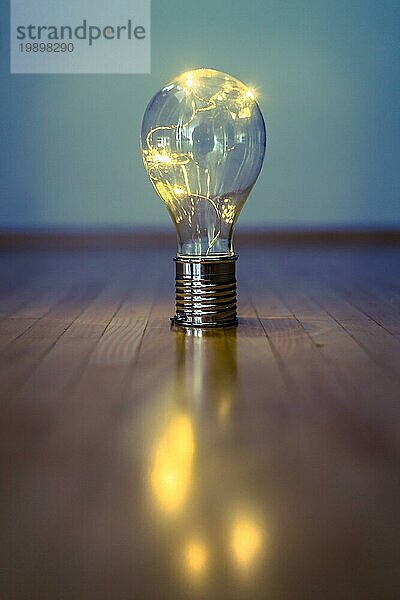 Die LEDglühbirne liegt auf dem Holzboden. Symbol für Ideen und Innovation. Raum kopieren
