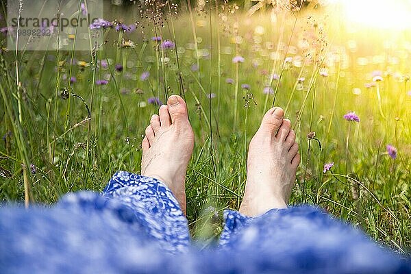 Junges Mädchen im Park liegt im Gras und genießt den Tag