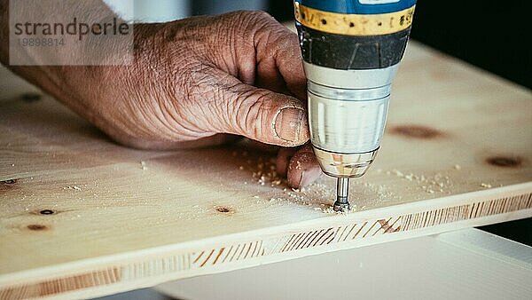 Handwerker bohrt mit Bohrmaschine in Holz