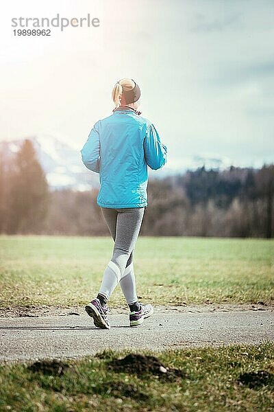 Junge Frau joggt  Landschaft