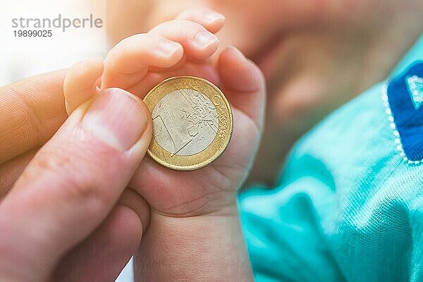 Nahaufnahme von neugeborenen Baby Hände halten eine Münze  Ruhestand Anordnung Konzept