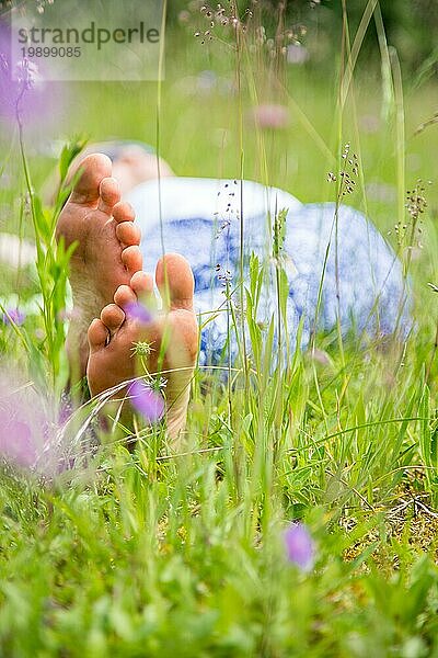 Junges Mädchen im Park liegt im Gras und genießt den Tag