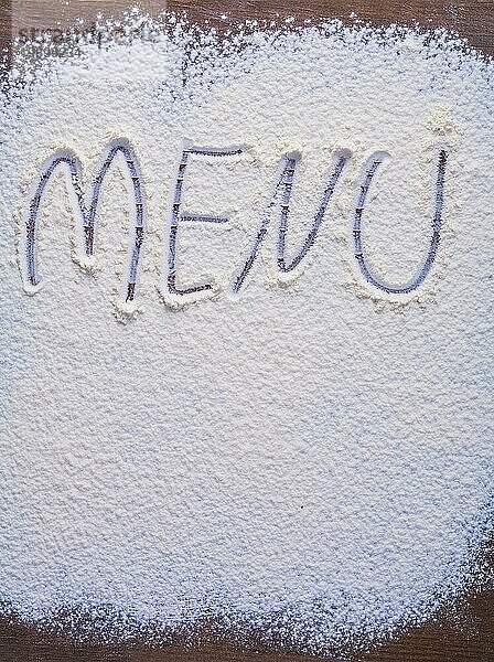 Handschriftliche Inschrift Menü ist mit Mehl auf Vintage Holztisch vertikale Version Essen und Trinken Konzept gemacht