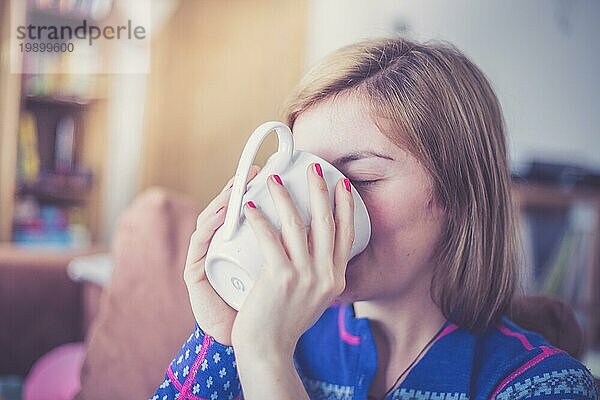 Schöne junge Frau genießt eine Tasse Tee