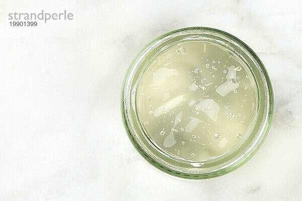 Aloe Vera Gel in einem Glasgefäß auf hellem Hintergrund  Aufnahme von oben mit Platz für Text